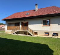 A family house in Liptovské Kľačany with a red roof and a well-maintained garden.