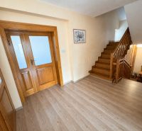 Interior of a family house with a staircase, wooden doors, and a floor with a wooden decor.