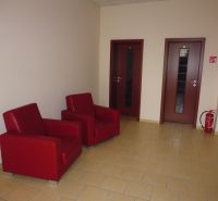Offices: Red chairs next to two doors and a fire extinguisher on the tiles.