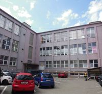 An office building on Masaryk Street in Prešov, in front of which cars are parked.