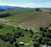 Aerial view of plots - housing in Plaveč, bordered by road and greenery.