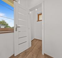 Interior of a family house with white doors and a wooden decor floor.