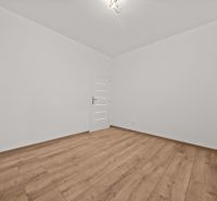 An empty room with white walls and a floor with a wooden decor in a family house.