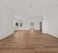A spacious room in a family house with a wooden decor floor and wooden windows.