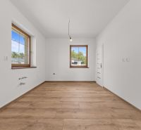 A room in a family house with white walls and a wooden decor floor.