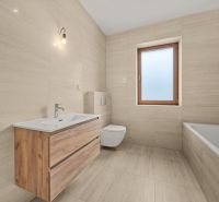A bathroom in a family house with a bathtub, sink, toilet, and window, floor with wooden decor.