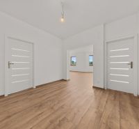 The interior of a family house with white doors and a floor with a wooden decor.