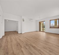 Interior of a family house with a wooden decor floor and large windows.