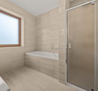 A bathroom with a bathtub, shower, and window in a family house.