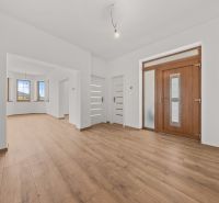 A family house with a wooden decor floor, white walls, and wooden doors.