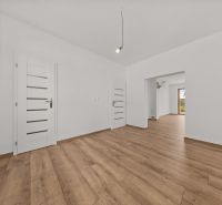 Interior of a family house with white walls and a floor with a wooden decor.
