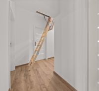 Interior of a family house with a wooden ladder leading to the attic and a floor with a wooden decor.