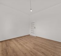 A room with white walls and a wooden decor floor in a family house.