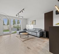 Living room with a leather sofa and windows to the terrace in a family house.