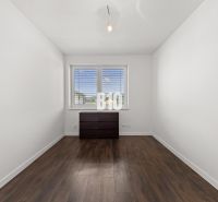 A room in a family house with a window, a dresser, and a floor with a wooden decor.