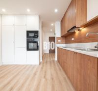 A kitchen in a 3-room apartment with white cabinets and a wood-patterned floor.