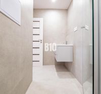 Bathroom in a 3-room apartment with a simple design and a wall-mounted sink.