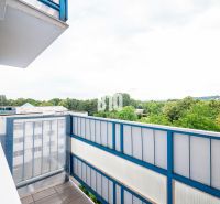 The balcony of a 3-room apartment in Nitra with a view of greenery and rooftops.