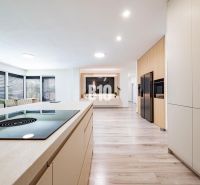 A kitchen in a family house with a wooden decor floor and modern furnishings.