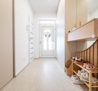 Interior of a family house with a bright hallway, shoe cabinet, and mirror.