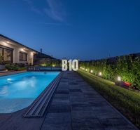A night garden at a family house in Nitra with a lit-up pool and terrace.