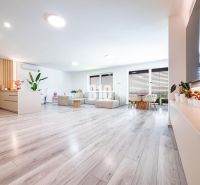 Spacious living room with wood-decor flooring and large seating area in a family house.