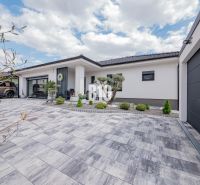 A family house in Nitra with a terraced paved area and a landscaped front garden.