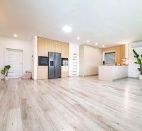Interior of a family house with a wooden decor floor and a modern kitchen.