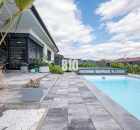 A family house in Nitra with a terrace, swimming pool, paving, and exotic plants.