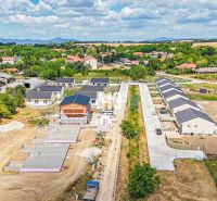Construction of family houses in Nitra surrounded by green landscapes and other properties.