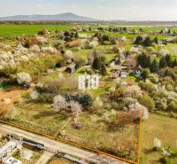 A residential building plot in Nitra surrounded by greenery and blooming trees.