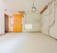 An unfinished room with bare walls and hanging cables in a family house.
