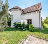 A family house in Nitra with windows, a garden, and a sloped roof in a green area.