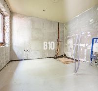 Partially reconstructed room in a family house with unfinished installations and bare walls.