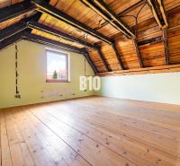 The attic of a family house with a wooden decor floor and roof beams.