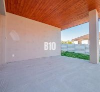 The terrace of a family house in Nitra with a wooden ceiling and an adjacent concrete fence.