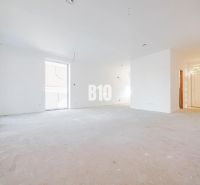 A spacious white interior of a family house with plenty of natural light and balcony doors.