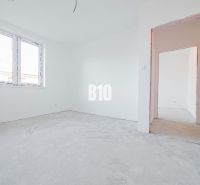 The interior of a family house with white walls and a concrete floor.