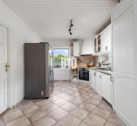 A kitchen with white cabinets and appliances in a family house.