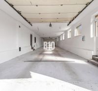 A spacious garage in a family house in the city of Nitra with several windows and white walls.