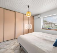Bedroom in a family house with a large built-in wardrobe, air conditioning, and a window.