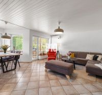 A spacious living room in a family house with a dining table and a comfortable sofa.