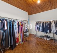 A wardrobe in a family house with hanging rods and a wooden decor floor.