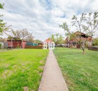 The garden of a family house in Nitra with a lawn and a walkway.