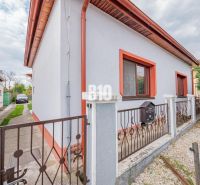 A family house in Nitra with a white facade, red trim, and a garden.