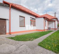 A family house in Nitra with a red roof, a yard, and simple garden landscaping.