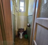A bathroom in a 2-room apartment with a window and a floor with a wooden decor.