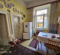 A kitchen in a 2-room apartment with wall plates and a wooden table.