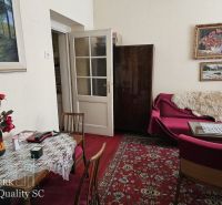 A classic living space in a 2-room apartment with a red carpet and paintings.