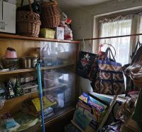 A room with storage spaces, baskets, and cleaning supplies in a 2-room apartment.